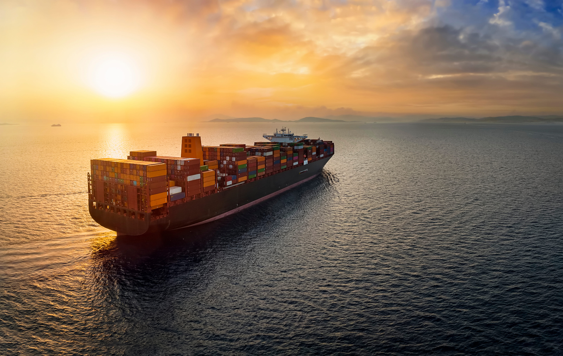 Container ship at sea during sunset